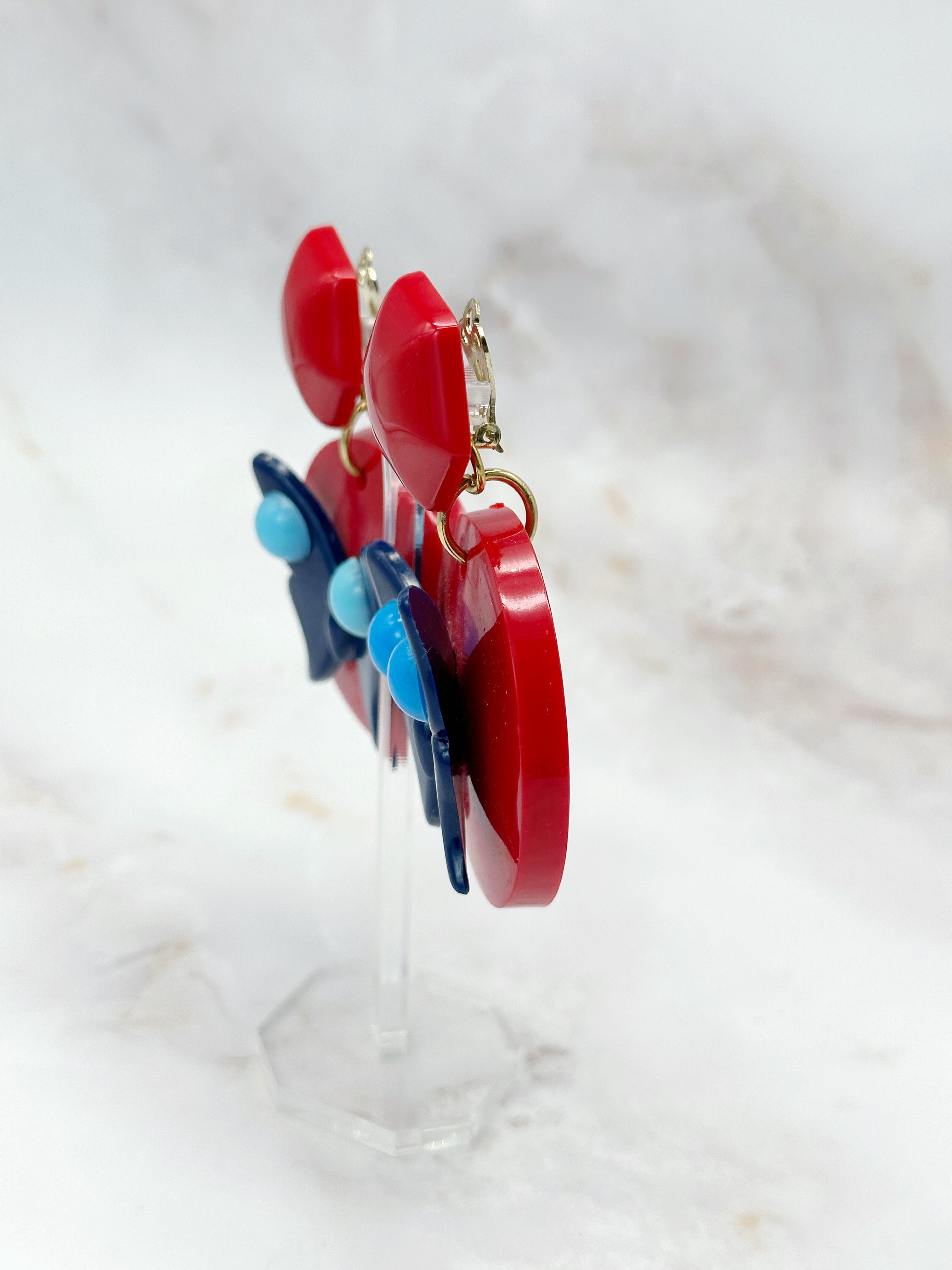 Statement Ohrclips mit blauem Schmetterling und rotem Kunststoff
