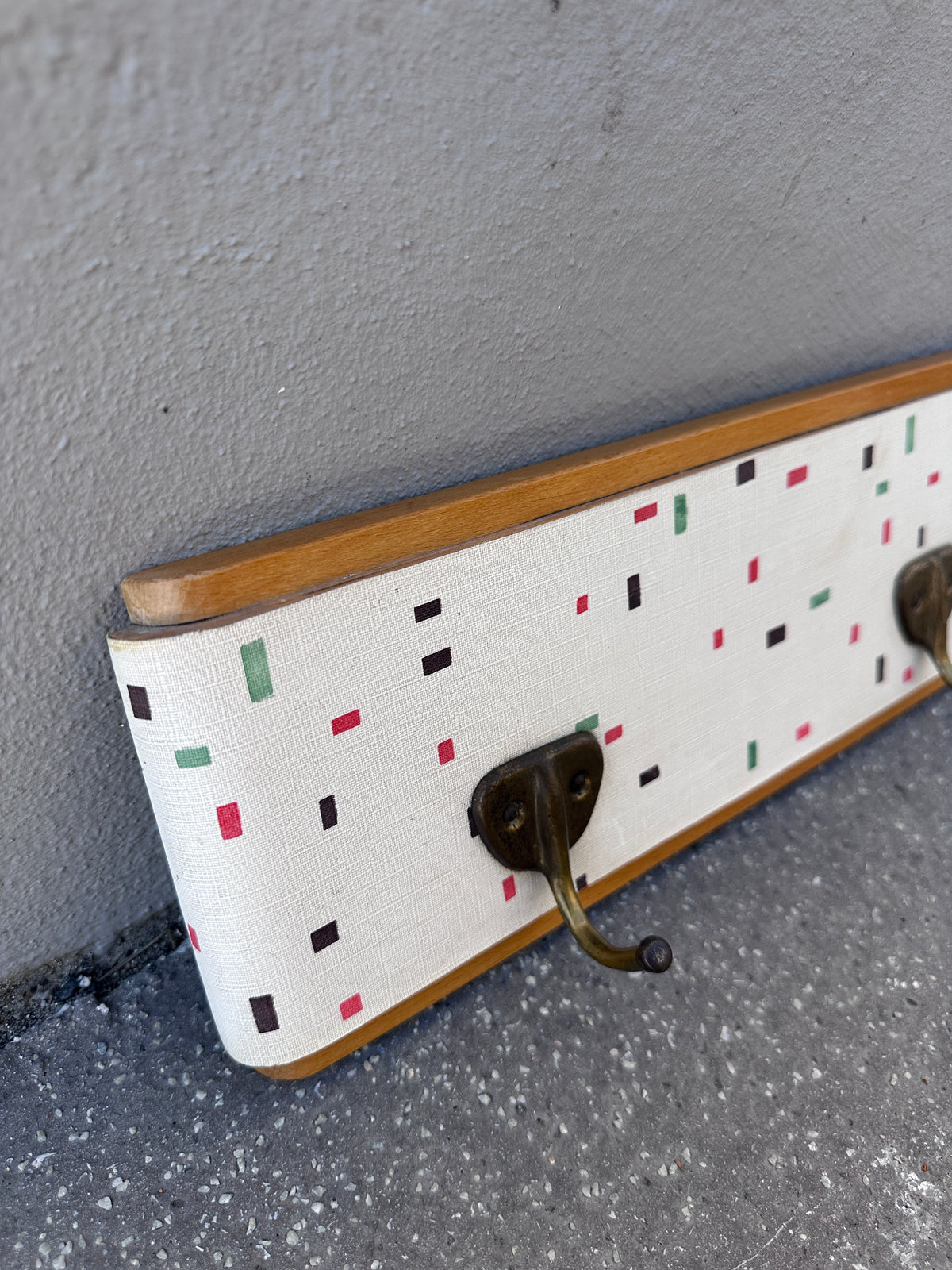 Vintage Garderobe mit buntem Muster und Messinghaken um 1950