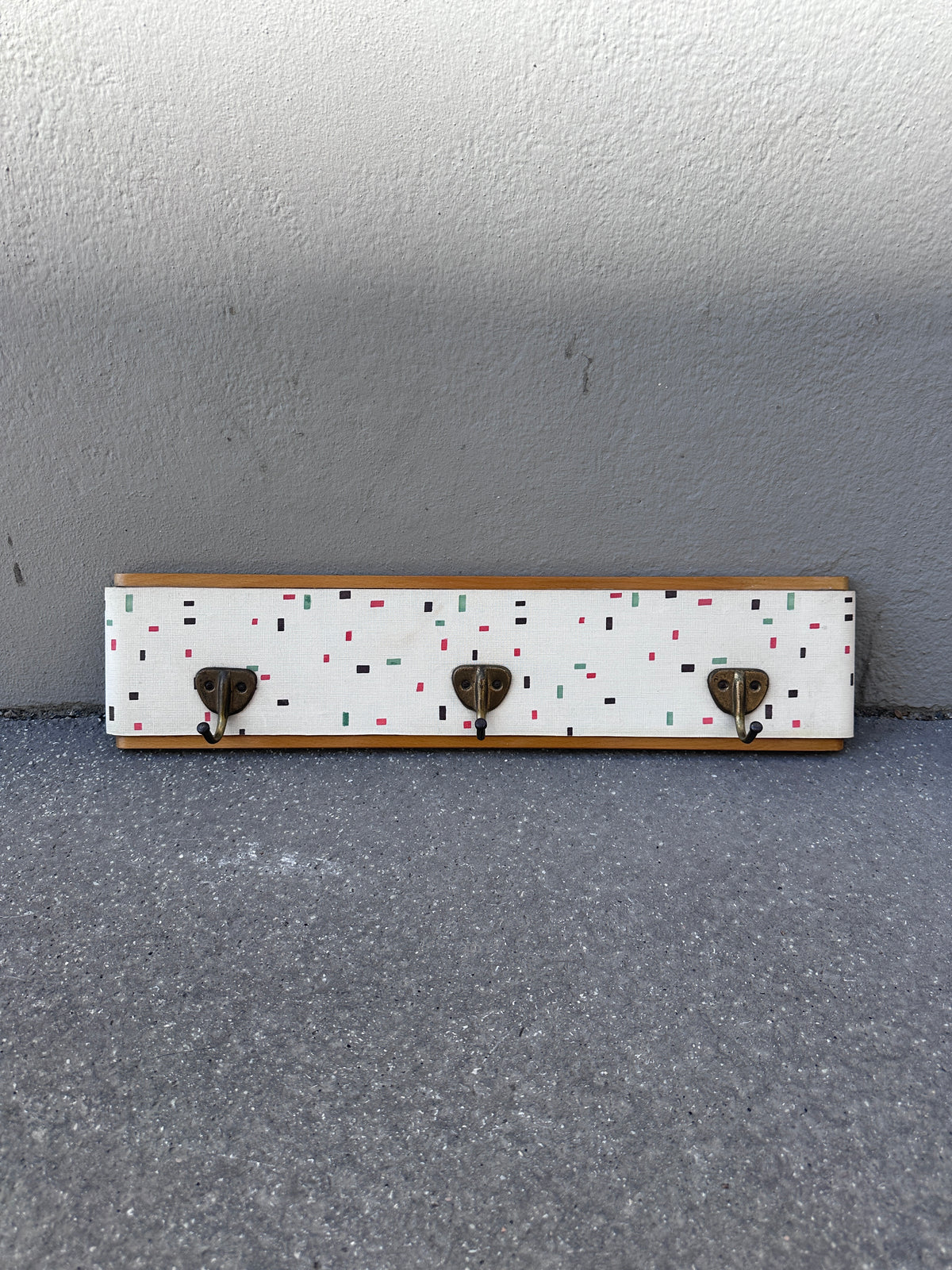 Vintage Garderobe mit buntem Muster und Messinghaken um 1950