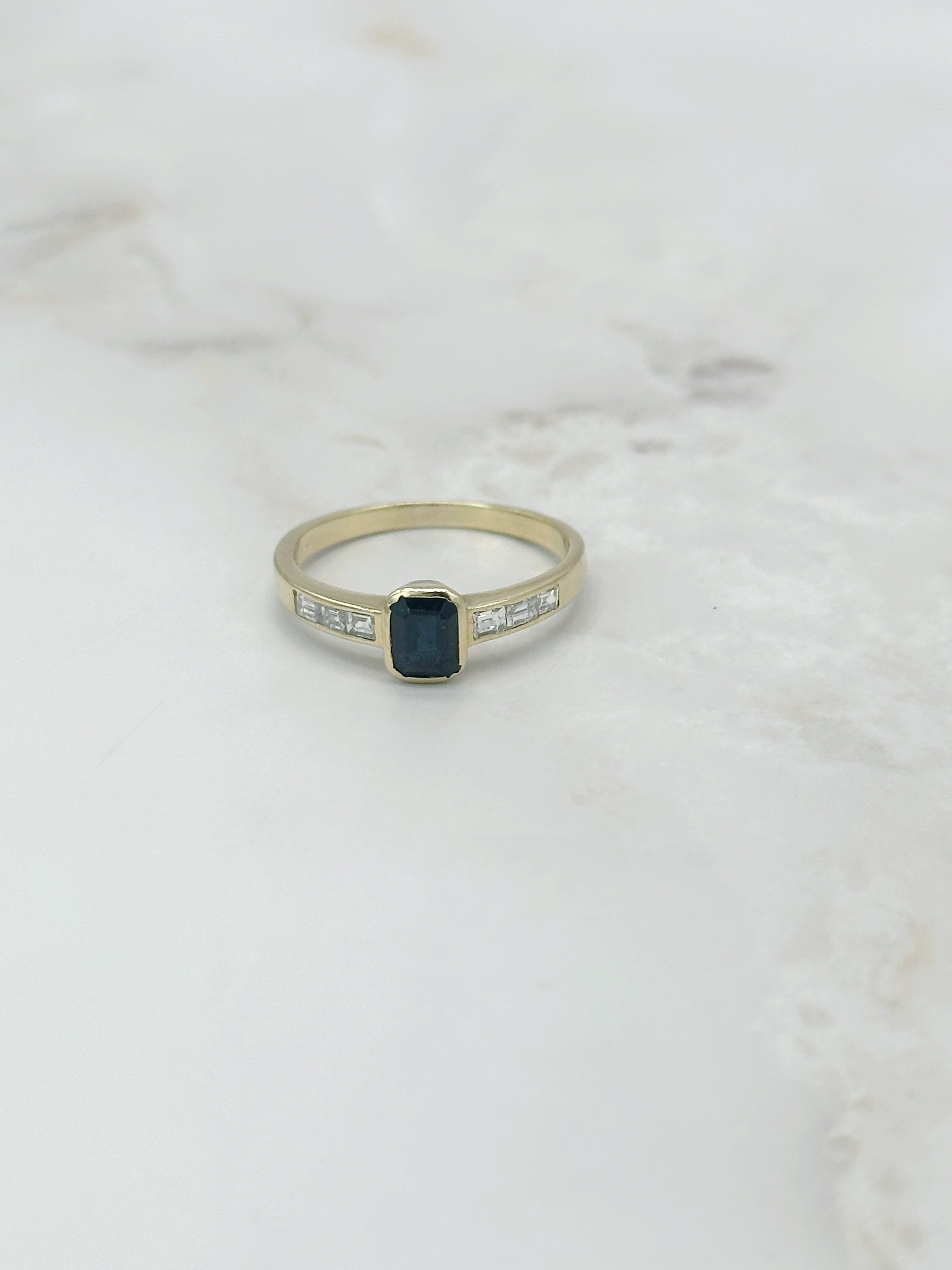 Ring in 750 Gelbgold mit dunkelblauem Saphir und Diamant-Baguetten