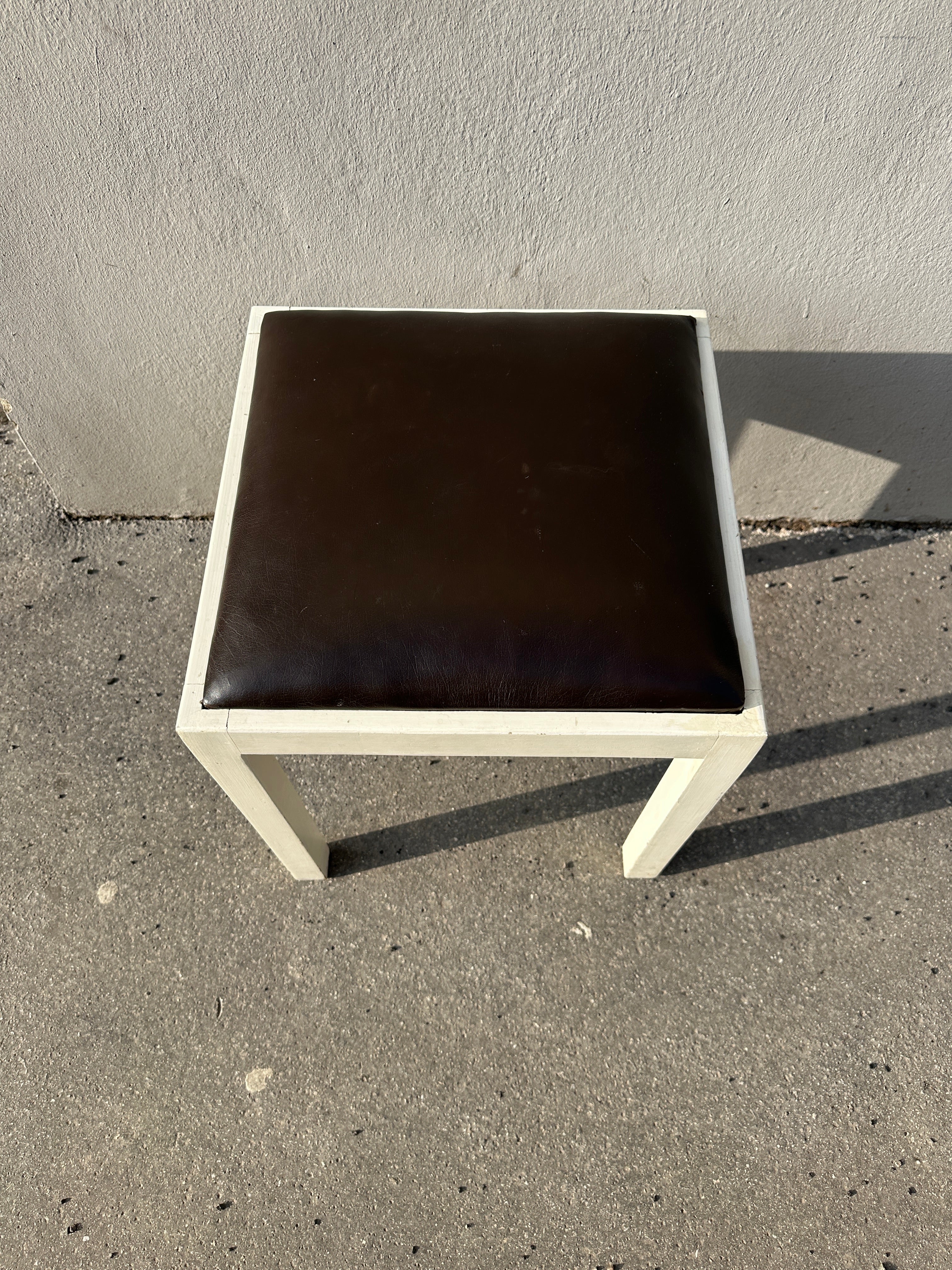 Weißer Holz-Hocker quadratisch mit dunkelbraunem Lederpolster