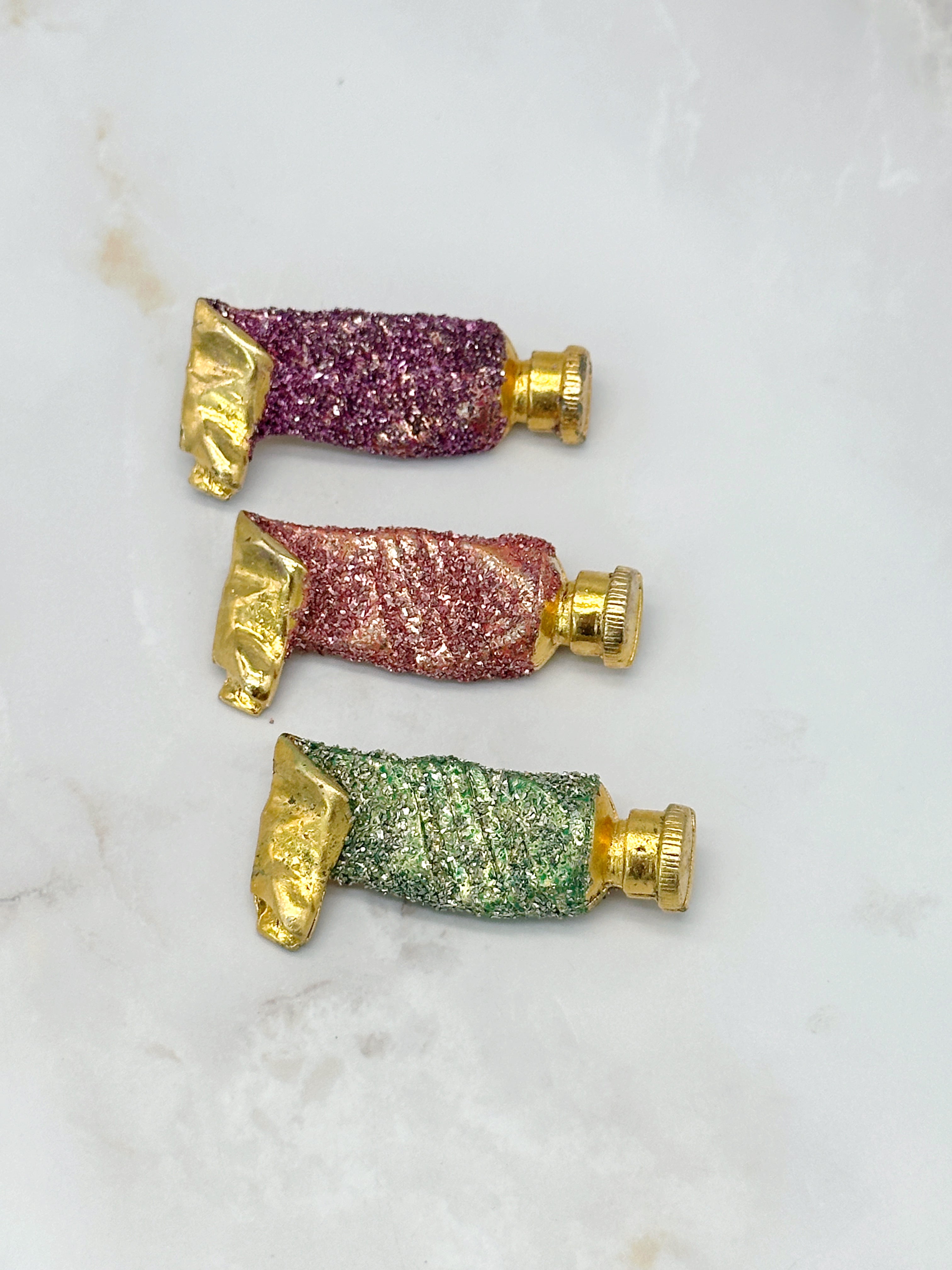 Vergoldete Brosche in Tubenform mit Glitzer in Rosa, Grün oder Lila