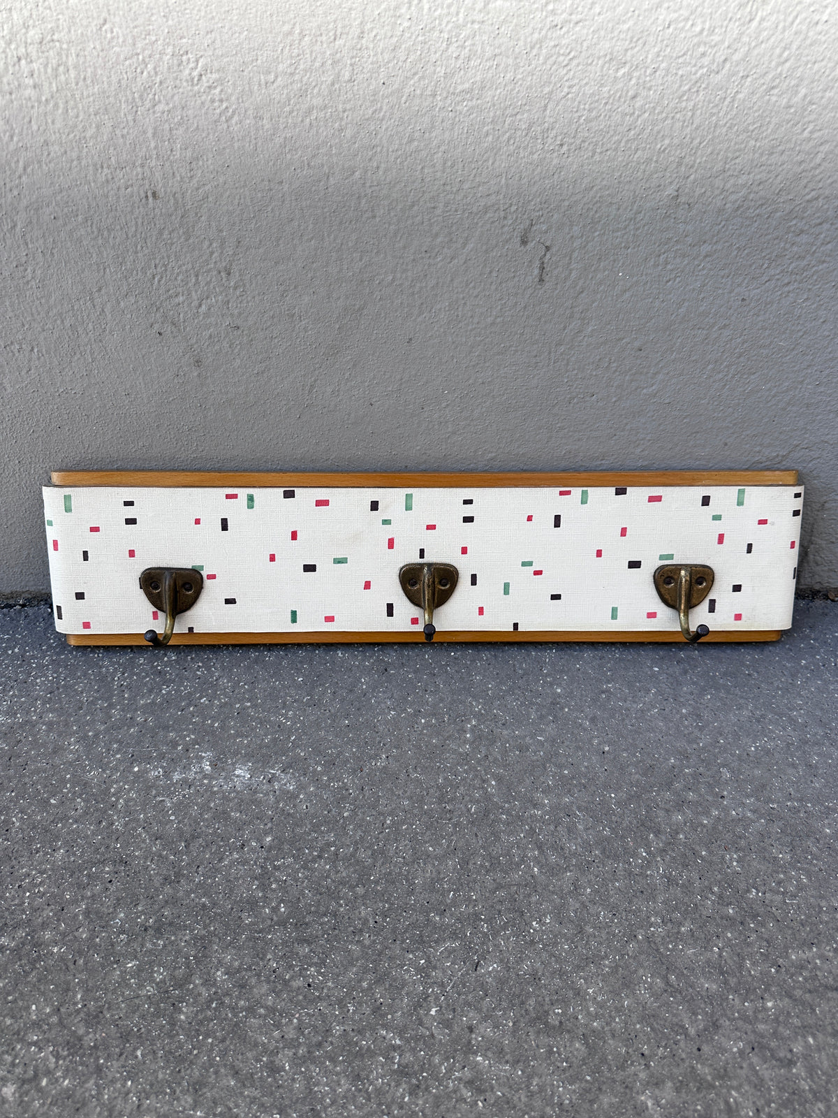 Vintage Garderobe mit buntem Muster und Messinghaken um 1950