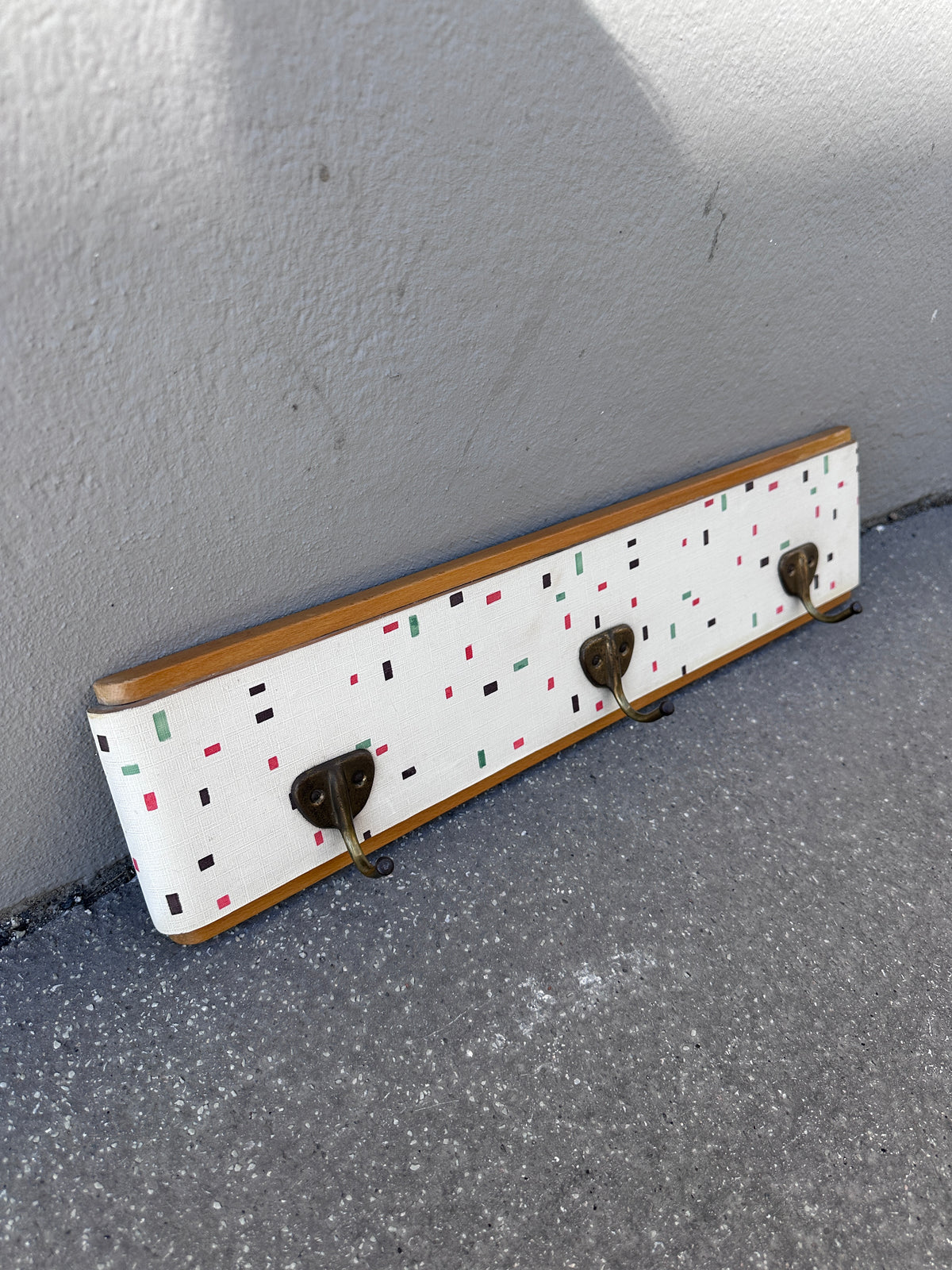 Vintage Garderobe mit buntem Muster und Messinghaken um 1950